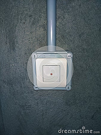 Anti-theft pushbutton with light grey surface on cement wall in Stock Photo