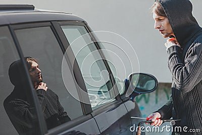 Thieft man holding screwdriver breaking into car Stock Photo