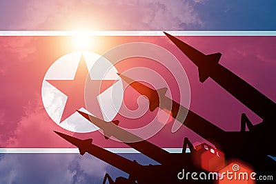 Antiaircraft rockets silhouettes on background of North Korea flag. Stock Photo