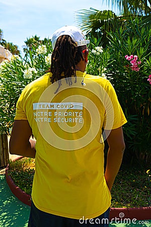 Antibes, France. 26.07.2020 Man in yellow t-shirt team covid. Health care. Character covid protection team for medical Editorial Stock Photo