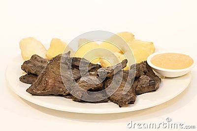 Anticuchos, Peruvian cuisine, grilled skewered beef heart meat with boiled potato and aji sauce chili Stock Photo