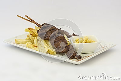 Anticuchos, Peruvian cuisine, grilled skewered beef heart meat with fries potatoes (french fries). Stock Photo