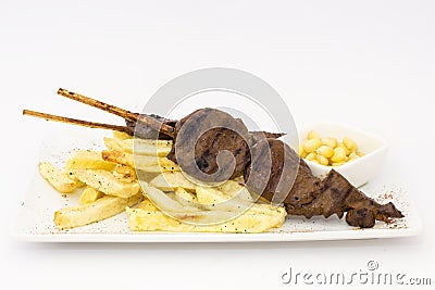 Anticuchos, Peruvian cuisine, grilled skewered beef heart meat with fries potatoes (french fries). Stock Photo