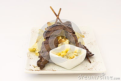 Anticuchos, Peruvian cuisine, grilled skewered beef heart meat with fries potatoes (french fries). Stock Photo