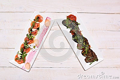 Antipasti on square plates. Appetizer and catering concept Stock Photo