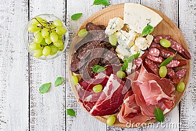 Antipasto catering platter with bacon, jerky, sausage, blue cheese and grapes Stock Photo