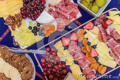 Antipasto platters with prosciutto, cheese, strawberries, grapes, dried fig Stock Photo