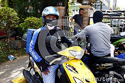 Rider and delivery man of a motorcycle courier service company Editorial Stock Photo