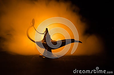 Antique arabian nights style oil lamp with soft light white smoke, Dark background. Lamp of wishes concept. Toned Stock Photo