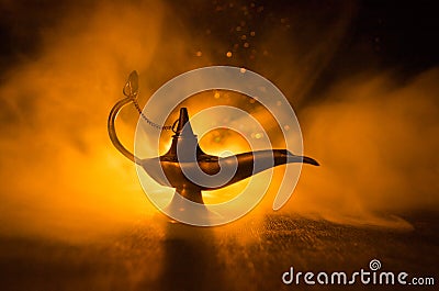 Antique arabian nights style oil lamp with soft light white smoke, Dark background. Lamp of wishes concept. Toned Stock Photo