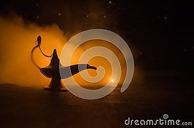 Antique arabian nights style oil lamp with soft light white smoke, Dark background. Lamp of wishes concept. Toned Stock Photo