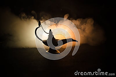 Antique arabian nights style oil lamp with soft light white smoke, Dark background. Lamp of wishes concept. Toned Stock Photo