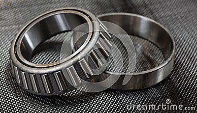 Automotive tapered roller bearing and race on carbon fiber cloth Stock Photo