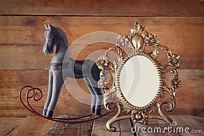 Antique blank victorian style frame and old rocking horse over wooden table Stock Photo