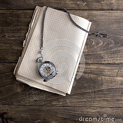 Antique book and pocket watch on grunge wooden table Stock Photo