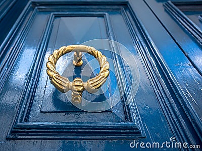 Antique brass door knocker on blue door. Stock Photo