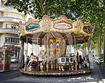 Antique carousel running in a French square Editorial Stock Photo