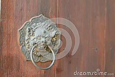 Antique Chinese lion handle on wooden door - with copy space Stock Photo