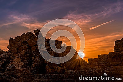 Antique city ruins under sunset with scattered clouds Stock Photo