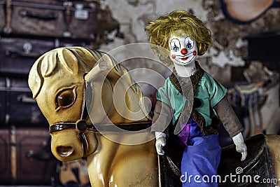 antique clown doll on vintage hobby horse Stock Photo