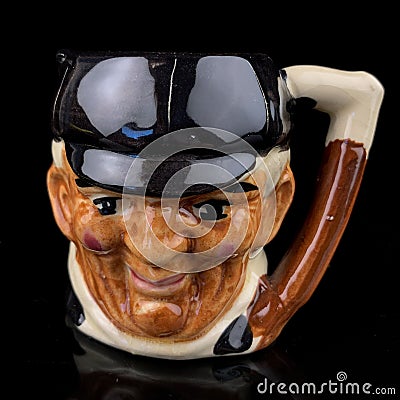 Antique coffee cup in the shape of a man`s head on a black background. Editorial Stock Photo