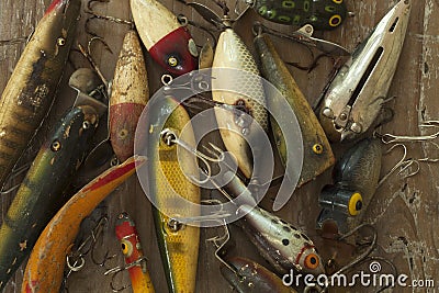 Antique fishing lures on rough wood surface viewed from above Stock Photo