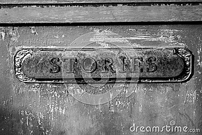 Antique letter slot relabeled as stories in black and white Stock Photo