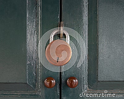 Antique locked with old rusted padlock on green door. Stock Photo