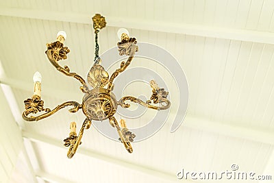 Antique luxurious golden metal brass chandelier cieling lamp light bulb interior for home and living architecture vintage Stock Photo