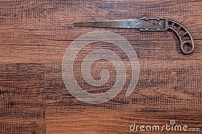 Antique miniature metal saw on a hardwood workbench - top right Stock Photo