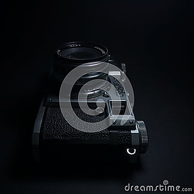 Antique obsolete russian or soviet professional dslr camera with film from ussr, retro photography equipment in darkness against Editorial Stock Photo