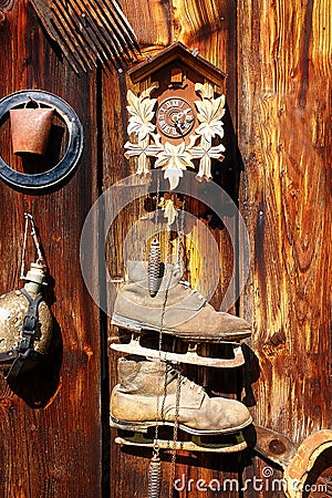 Antique old style retro object assemblage on a wooden wall. rustic stile. Clock, bell, old skates and others. Stock Photo