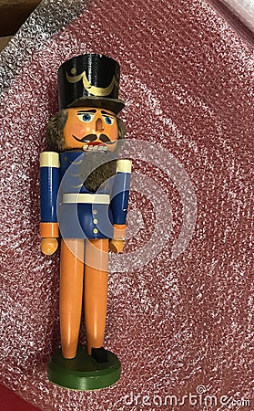 An antique old wooden German Nutcracker lies on the packing film on the left. Stock Photo