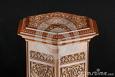 Antique oriental wooden table with the artistic carving on a black background, Uzbekistan, close-up Stock Photo