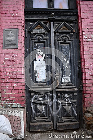 Antique ornate door and architectural details of dilapidated building with red brick wall Editorial Stock Photo