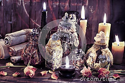 Antique parchments with magic witch bottles and burning candles Stock Photo