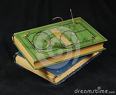 Antique reading glasses and old books Stock Photo