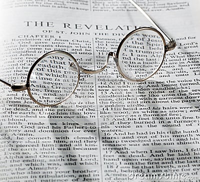 Antique reading glasses on page of bible Stock Photo