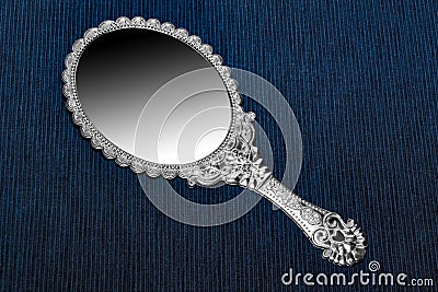 Antique retro hand mirror on dark blue background Stock Photo