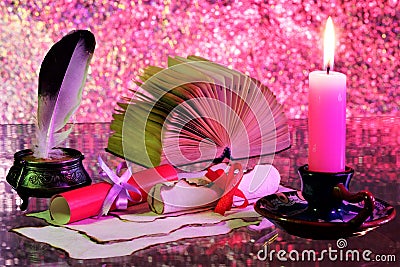 Antique scrolls of paper written with a pen by candlelight, and a book. Vintage grunge paper, rainbow colors of bokeh lights- Stock Photo