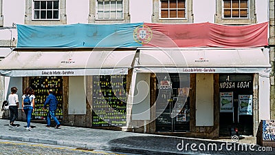 Antique shop of the famous drinks in the center of Porto, Portugal with Portuguese flag draped outside Editorial Stock Photo