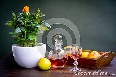 Antique stylized still life with a bouquet of roses, a decanter of wine and apples. Stock Photo