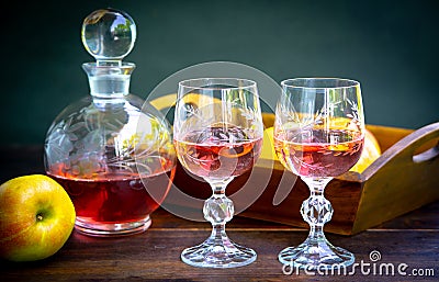 Antique stylized still life with a bouquet of roses, a decanter of wine and apples. Stock Photo