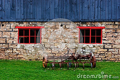 Antique tiller beside a barn Stock Photo