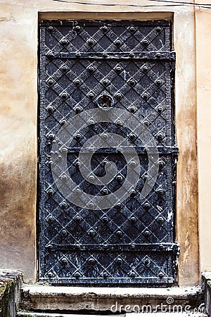 Antique vertical front door to the Middle Ages. Ancient aged closed vintage retro gothic grunge black iron metal door gate in old Stock Photo