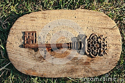 Old ornate skeleton key on rough wood background Stock Photo