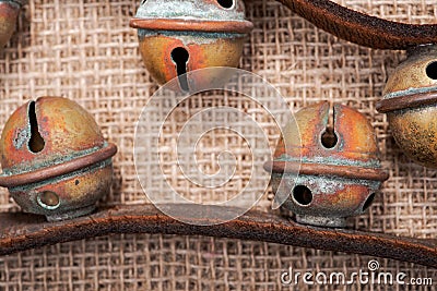 Antique vintage oxidize brass sleigh bells on leather strap and burlap Stock Photo