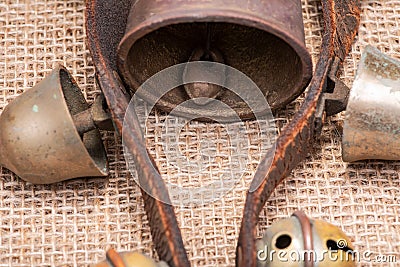 Antique vintage oxidize brass sleigh bells on leather strap and burlap Stock Photo