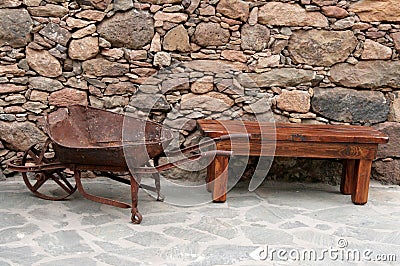 Antique wheelbarrow and bench Stock Photo