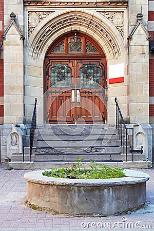 Antique wooden door with windows, carved stone arch and steps of the entrance of a historical building in Montreal, Quebec, Canada Editorial Stock Photo